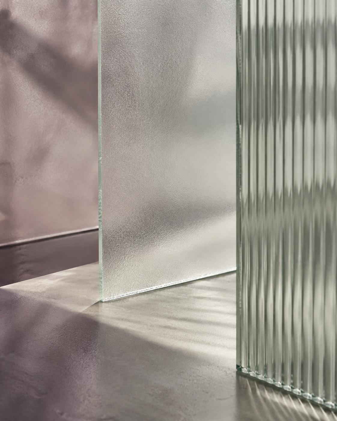 Overlapping frosted and reeded glass panels in porcelain, mauve and sage tints.